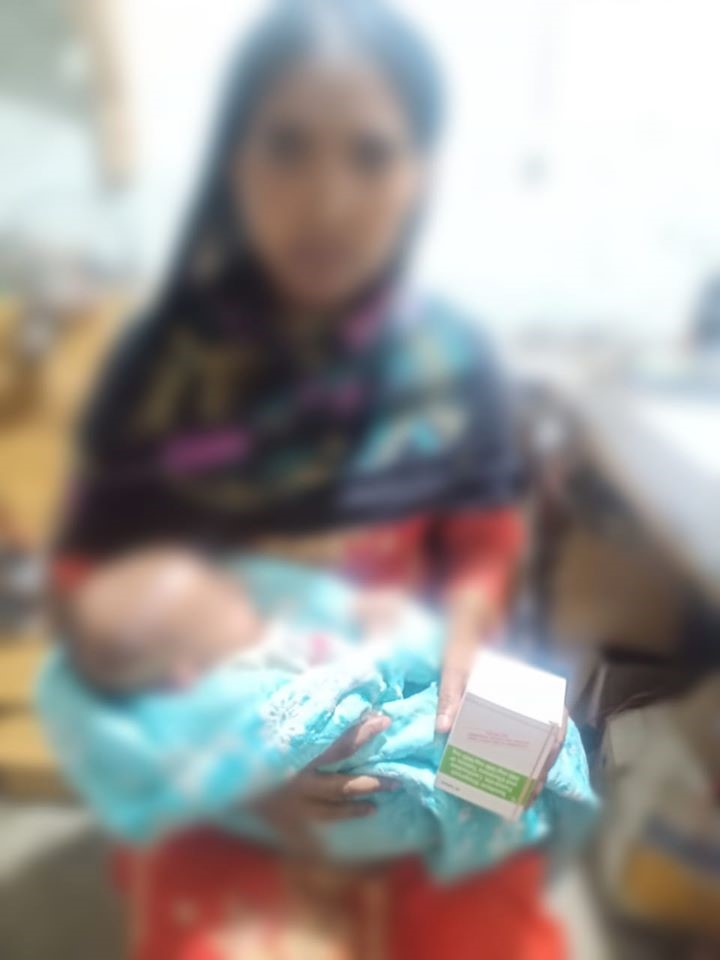 Seema with her new born child. Image blurred to conceal her true identity.